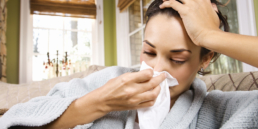 Mulher assoando o nariz com coriza, um dos sintomas mais comuns da gripe.