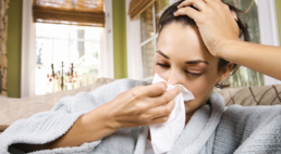 Mulher assoando o nariz com coriza, um dos sintomas mais comuns da gripe.