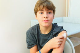 Imagem de um menino após ele tomar uma das vacinas para adolescentes recomendadas