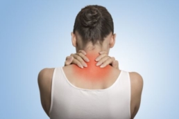 ilustração mostrando uma mulher de costas apalpando a parte de baixo do pescoço indicando sinais de fibromialgia