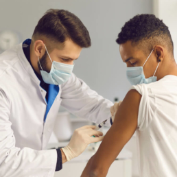 um médico aplicando uma vacina no braço de um menino - campanha de vacinação da gripe
