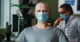 Homem de máscara careca fazendo tratamento contra o câncer anal
