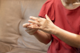 Pessoa tocando nos dedos na mão com medo de sofrer gota, um dos problemas de ácido úrico alto no sangue